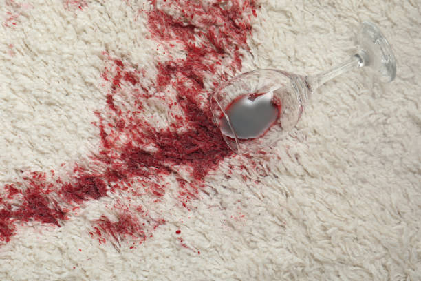 istock Overturned glass and spilled red wine on white carpet, top view 1328308659