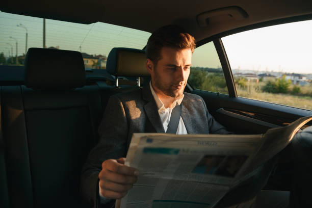 istock Smiling businessman reading newspaper 1328309357