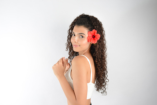 portrait of happy woman putting flower in her hair