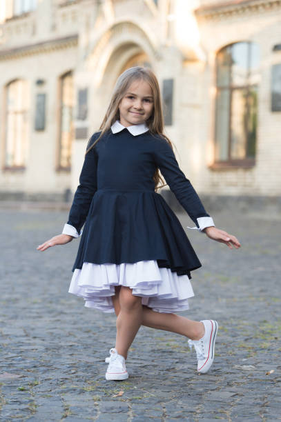 Dance etiquette. Happy child make curtsy outdoors. Small dancer wear school uniform. Back to school fashion. Dance education. Let your feet do the talking Dance etiquette. Happy child make curtsy outdoors. Small dancer wear school uniform. Back to school fashion. Dance education. Let your feet do the talking. curtseying stock pictures, royalty-free photos & images