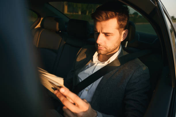 istock Handsome businessman reading newspaper while sitting 1328310977