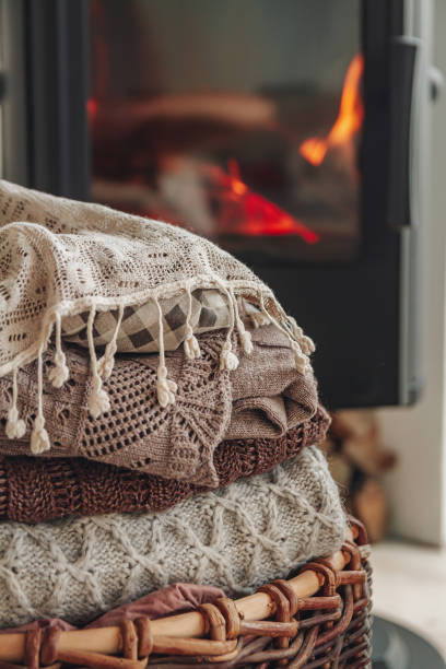 istock A stack of warm clothes in a wicker basket an iron fireplace wit 1328311318