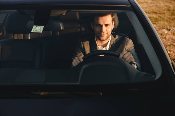 istock Front view of smiling bussinesman in suit driving 1328312376
