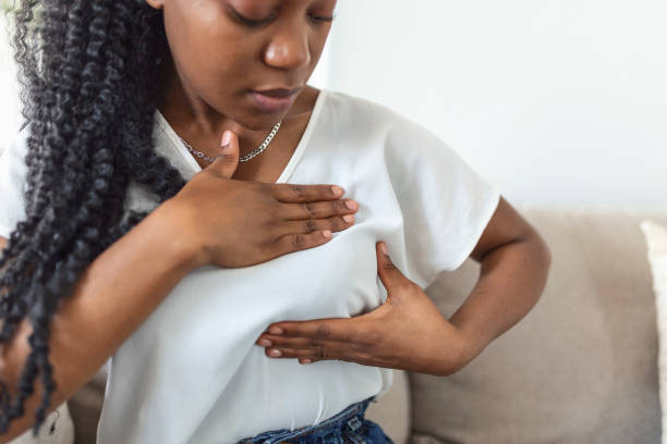 junge afroamerikanerin tastet ihre brust alleine ab, dass sie sich sorgen um brustkrebs machen. gesundheits- und brustkrebskonzept - breast sensuality women touching stock-fotos und bilder