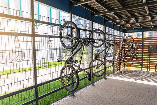 Apartment bicycle parking space, modern private bike vertical space-saving storage racks near residential building