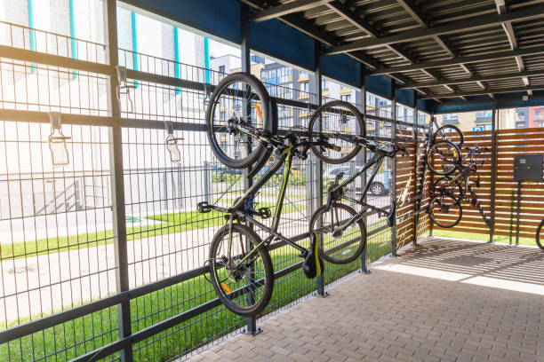 Bikes vertical space-saving parking near residential buiding Apartment bicycle parking space, modern private bike vertical space-saving storage racks near residential building minsk photos stock pictures, royalty-free photos & images