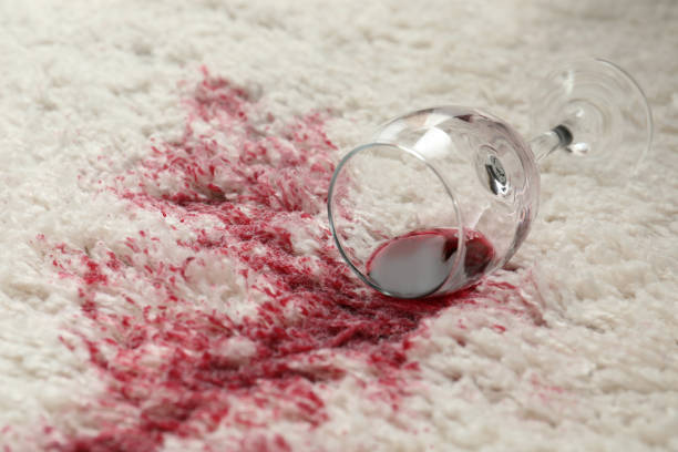 istock Overturned glass and spilled red wine on white carpet 1328315020