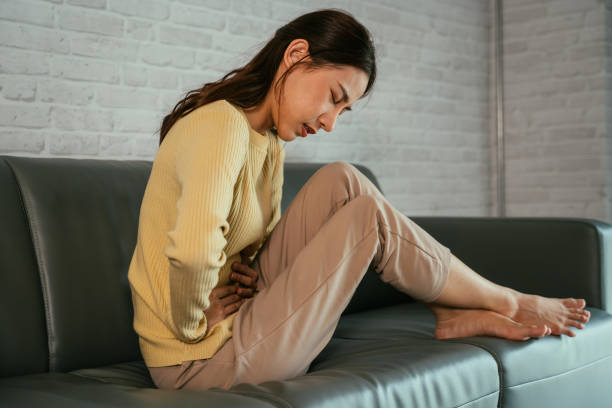 Young woman suffering from stomach ache stock photo