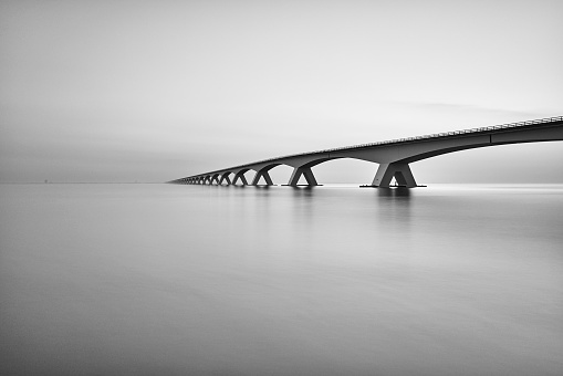 The Zeelandbrug on a cloudy day. The picture is in black and white.