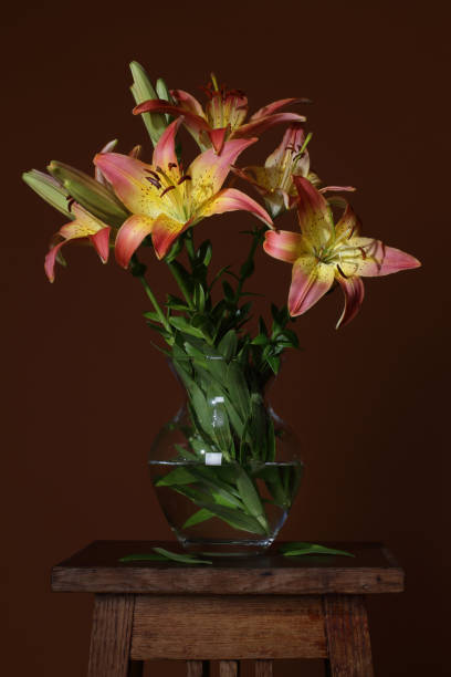 istock Vase with flowers lilies on a brown background 1328320744