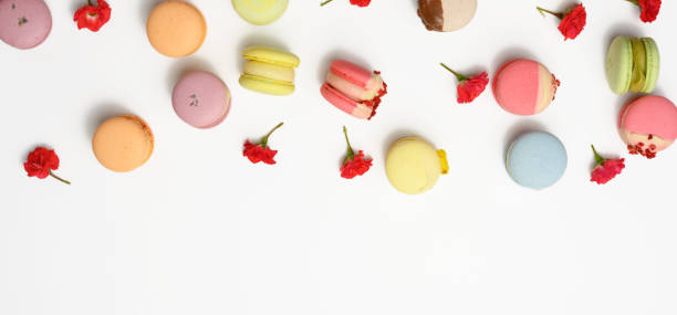 istock baked macarons with different flavors and rosebuds on a white background 1328321166