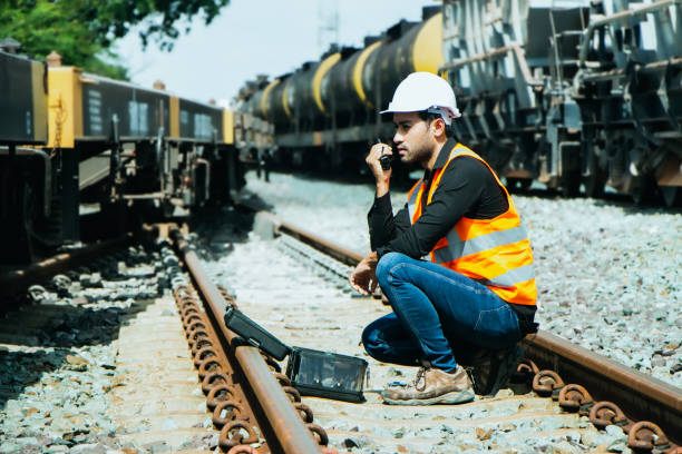 istock asian Inspector Engineering wearing helmet and vest worker unifrom checking railway construction work on rail track. 1328322853