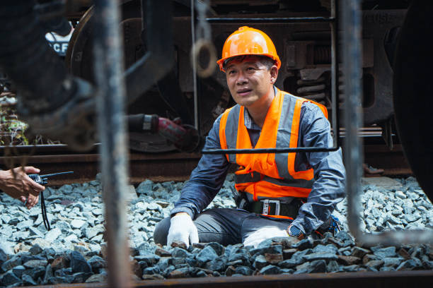 istock asian Inspector Engineering wearing helmet and vest worker unifrom checking railway construction work on rail track. 1328323425