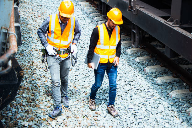 istock asian Inspector Engineering wearing helmet and vest worker unifrom checking railway construction work on rail track. 1328323449