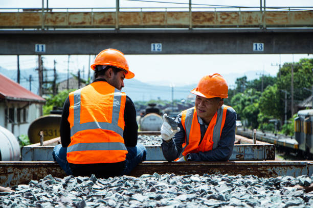 istock asian Inspector Engineering wearing helmet and vest worker unifrom checking railway construction work on rail track. 1328323462