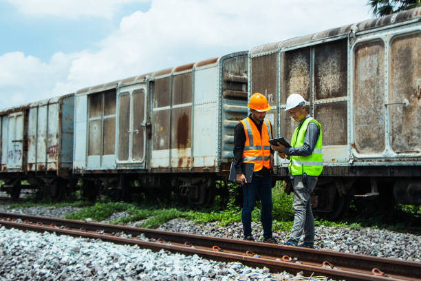 istock asian Inspector Engineering wearing helmet and vest worker unifrom checking railway construction work on rail track. 1328323512