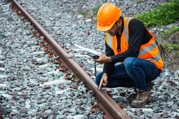 istock asian Inspector Engineering wearing helmet and vest worker unifrom checking railway construction work on rail track. 1328323567