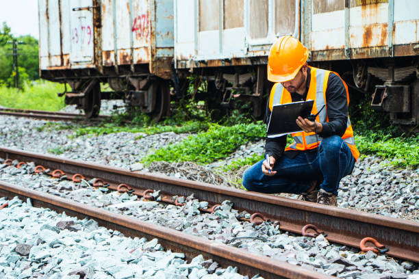istock asian Inspector Engineering wearing helmet and vest worker unifrom checking railway construction work on rail track. 1328323704