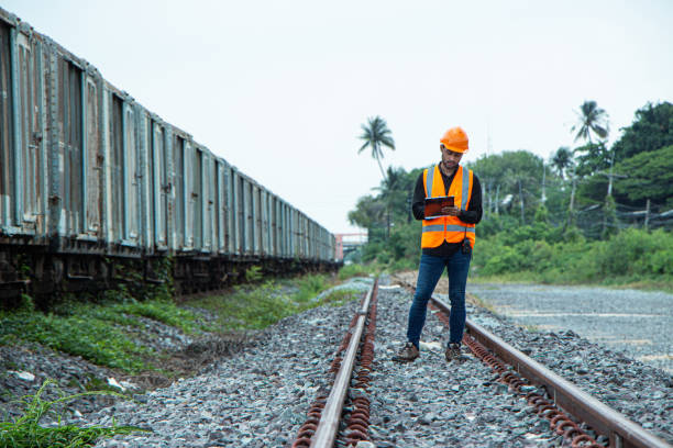 istock asian Inspector Engineering wearing helmet and vest worker unifrom checking railway construction work on rail track. 1328323812