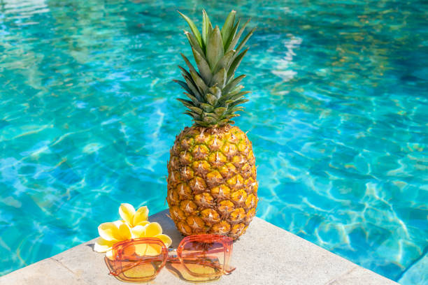 istock Juicy pineapple and glasses by the pool. Summer concept. 1328324074