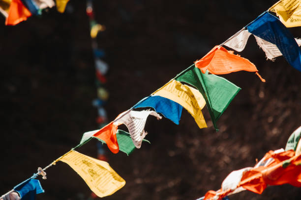 nahaufnahme der farbenfrohen buddhistischen bhutanischen tibetischen gebetsfahne, die die berge des pangan nyingma klosters im dorf patlikuhal in der nähe von manali, himachal pradesh, indien bedeckt - bhutanese flag stock-fotos und bilder