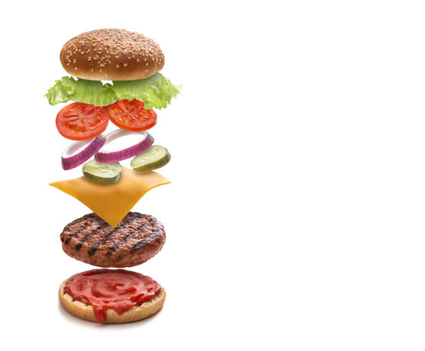 istock Burger layered ingredients as explosion flying open bun isolated on white 1328324337