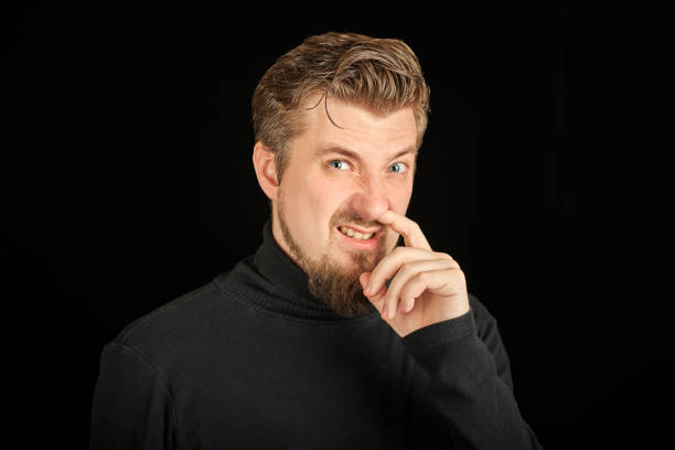 istock Funny bearded man picking his nose, black background 1328327433