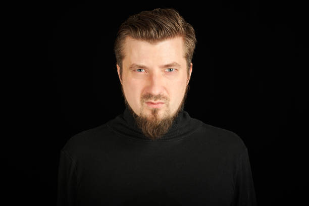 istock Tense bearded young guy in black polo neck sweater. 1328327440