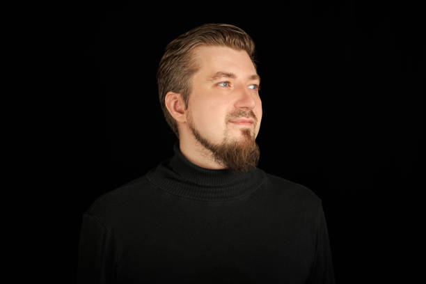 istock Cute bearded man, half-profile portrait, black background 1328327470