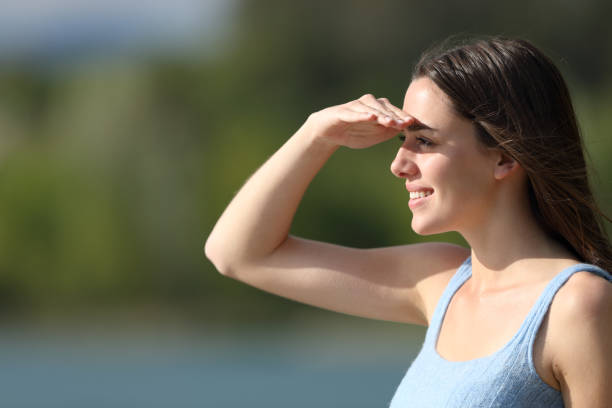 Woman looking away protecting from sun with the hand