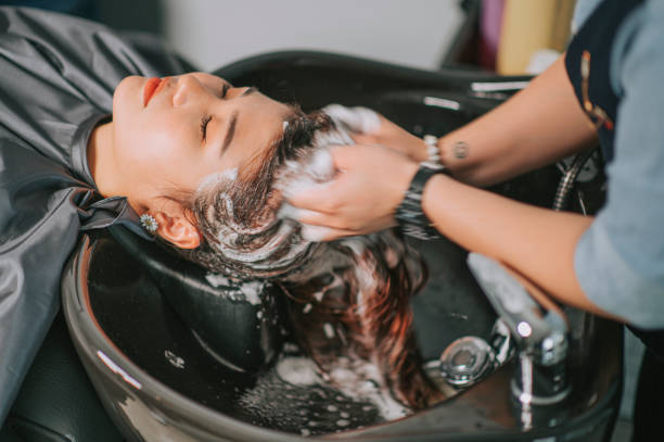 direttamente sopra la femmina cinese asiatica sdraiata per il lavaggio dei capelli al parrucchiere con gli occhi chiusi - salone di parrucchiere foto e immagini stock