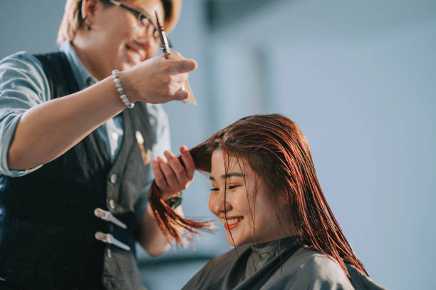 gros plan sur la coiffeuse chinoise asiatique coiffeuse coupant les cheveux pour son client dans le salon de coiffure - anticipation smiling touching image technique photos et images de collection