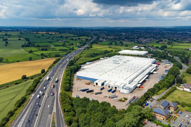 Large distribution centre next to M6 motorway, England, UK Wide angle aerial view of a large warehouse distribution centre next to the M6 motorway in the West Midlands, England, UK. birmingham england photos stock pictures, royalty-free photos & images
