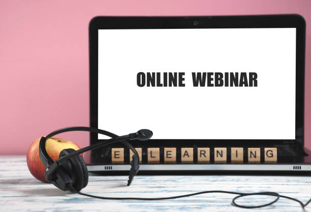 istock concept idea of electronic distance learning, webinar - earphone with microphone, apple, defocus on the background, inscription - on the screen online webinar 1328333509