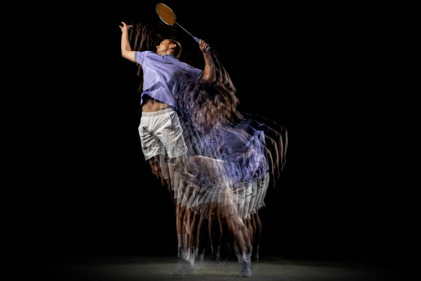 istock One young male badminton player, shuttler training isolated on dark background. Stroboscope effect. 1328336381