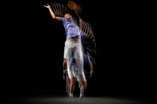 istock One young male badminton player, shuttler training isolated on dark background. Stroboscope effect. 1328336393