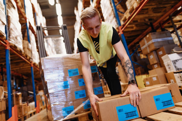 istock Warehouse employee in reflective uniform driving forklift 1328336759
