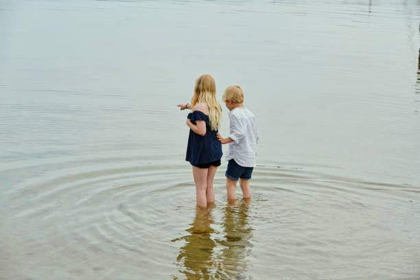 istock Children standing in water 1328337387