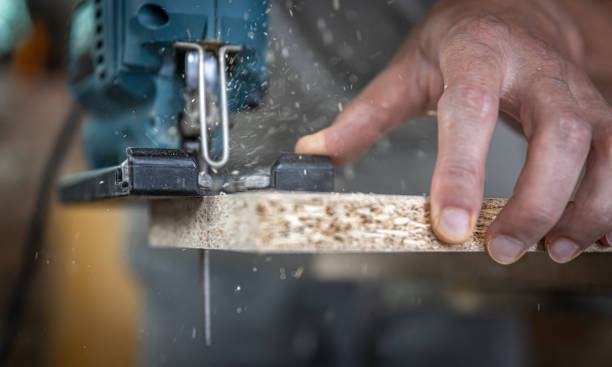 istock Close-up process of cutting wood board with jigsaw. 1328337804