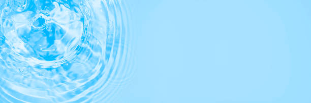 istock Surface of light blue transparent swimming pool water texture with circles on the water. Trendy abstract nature background. Water waves in sunlight long banner with copy space. 1328341122