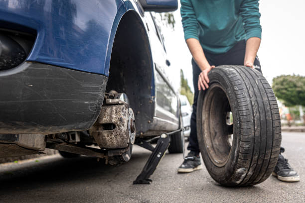 istock Close-up a man changes a tire in a car on the road. 1328344733