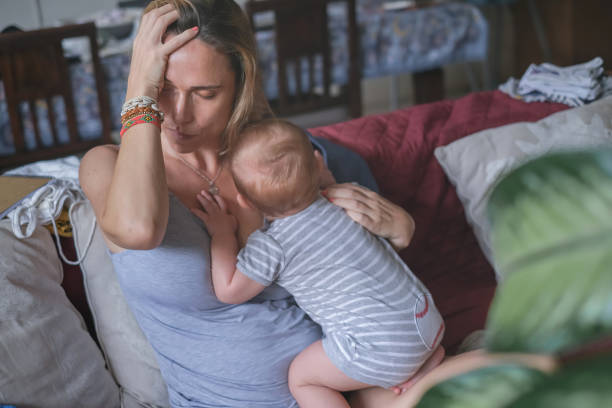 Depressed Mother Taking Care of a Newborn stock photo