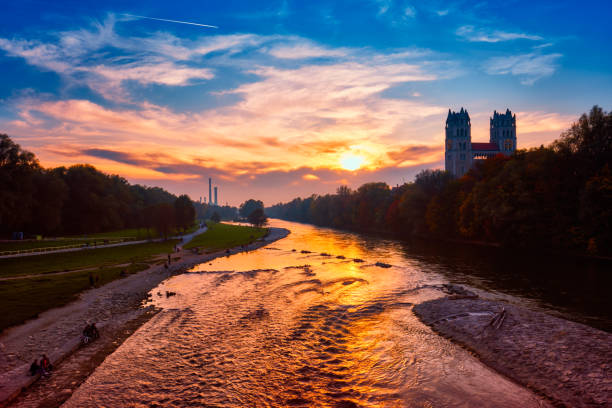 Munich view - Isar river, park and St Maximilian church from Reichenbach Bridge on sunset. Munchen, Bavaria, Germany.