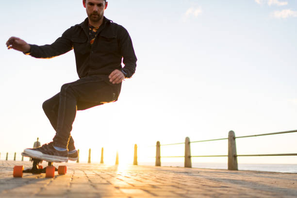 Teenagers ride longboards on the street from the back