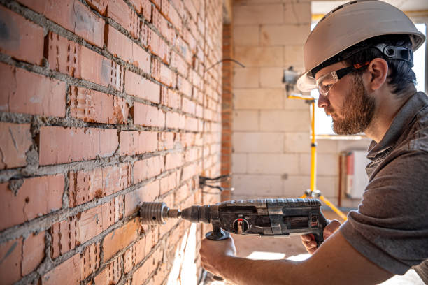 istock A builder in a helmet and goggles works with a drill. 1328346175