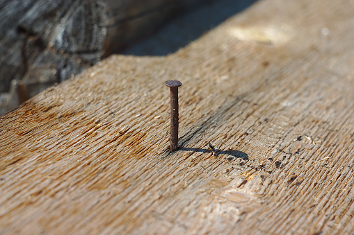 a rusty nail sticking out of an old board