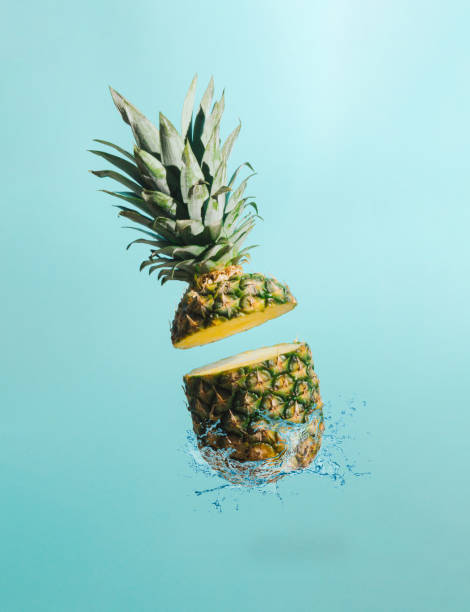 istock Sliced pineapple with water splash on pastel blue background. Minimal fruit concept. Summer tropical idea. 1328347009