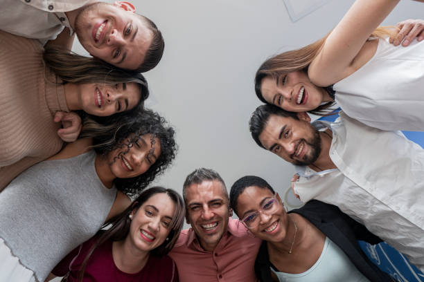 istock coworkers join their heads in a circle and look down at the camera that portrays them 1328347294
