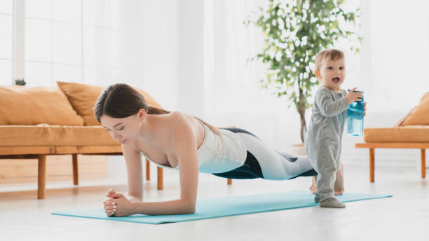 Young caucasian mother keeping fit shaping doing sport exercises at home, losing weight after labor and baby delivery. Postnatal period training with small kid toddler infant Young caucasian mother keeping fit shaping doing sport exercises at home, losing weight after labor and baby delivery. Postnatal period training with small kid toddler infant 8 months pregnant stock pictures, royalty-free photos & images