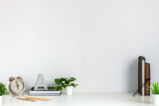 Desk arrangement. Workplace. Empty wall of copy space. Books and notebooks on the desk. Back to school.